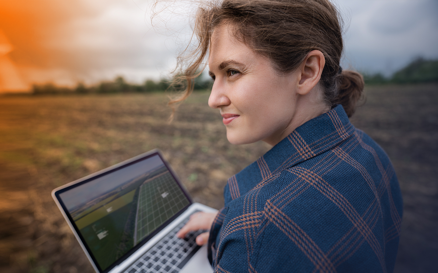 Frau mit Laptop auf einem Feld